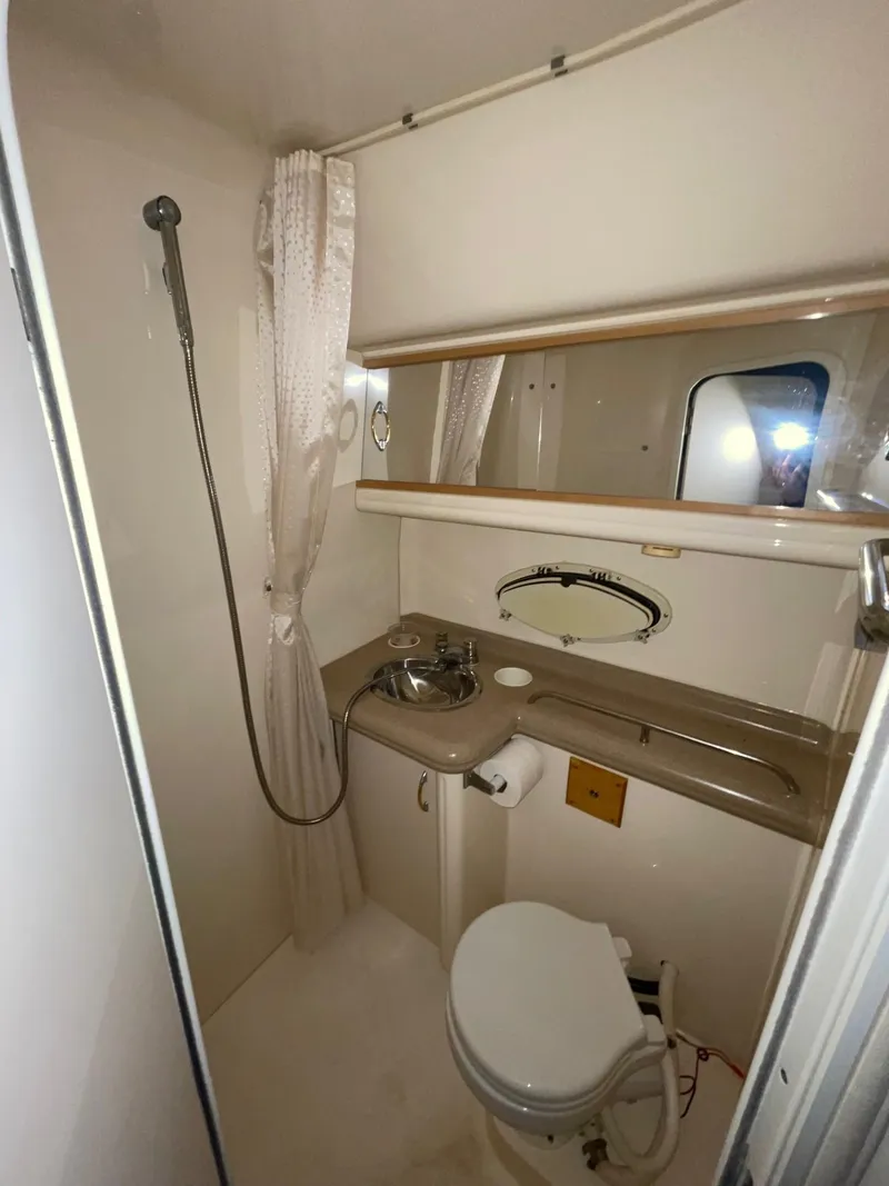 Slide: The Image of 1999 Larson 330 CABRIO boat bathroom with shower, sink, and toilet. - 32