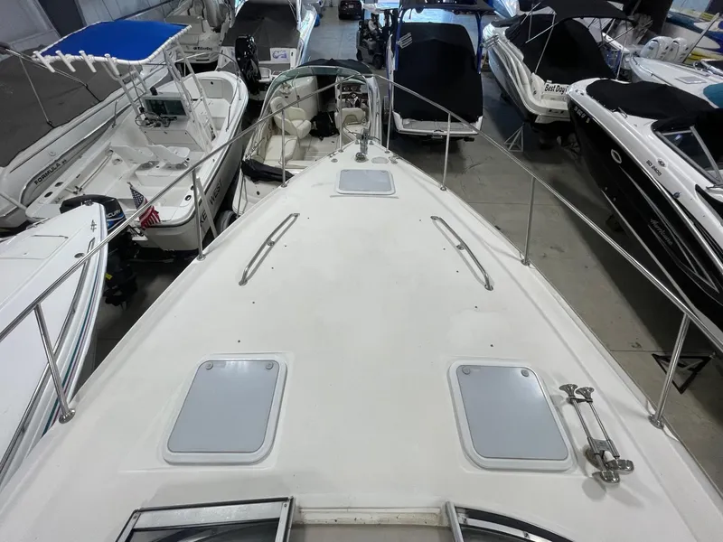 Slide: The Image of 1999 Larson 330 CABRIO boat deck view in a showroom with other boats. - 35