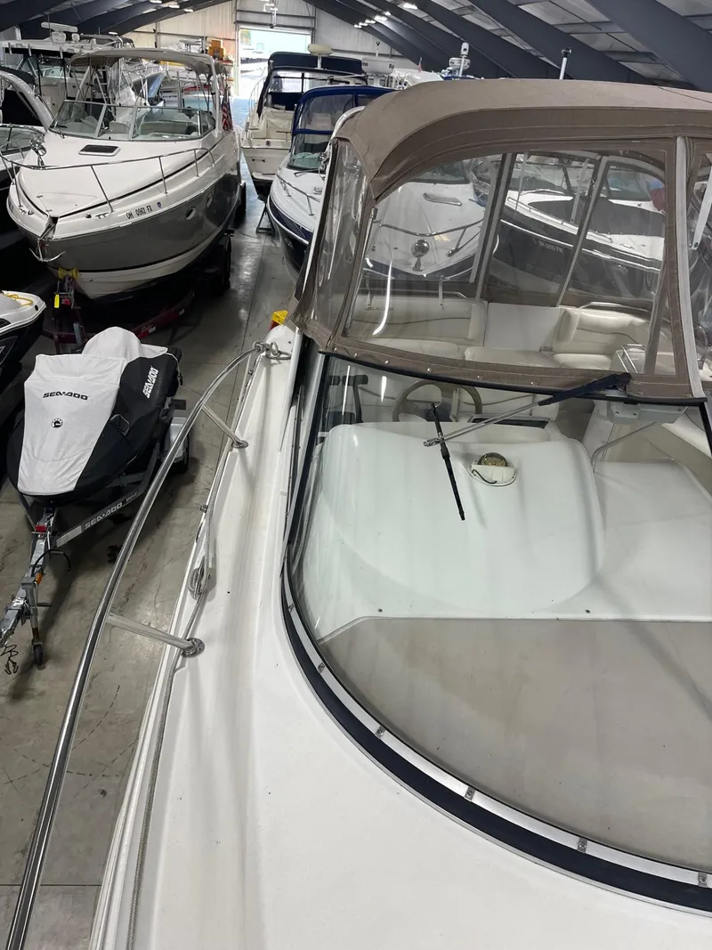 Slide: The Image of 1999 Larson 330 Cabrio boat in storage, surrounded by other vessels. - 39