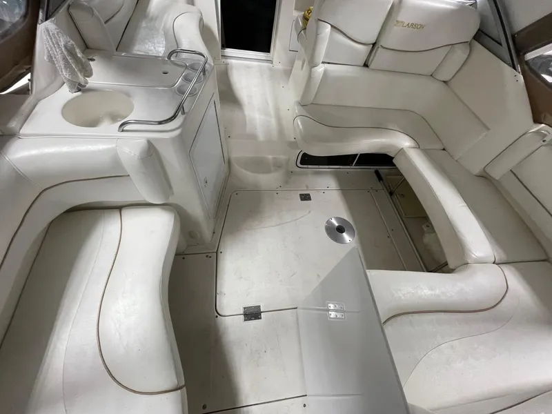 Slide: The Image of 1999 Larson 330 Cabrio boat interior with white seating and compact layout. - 4