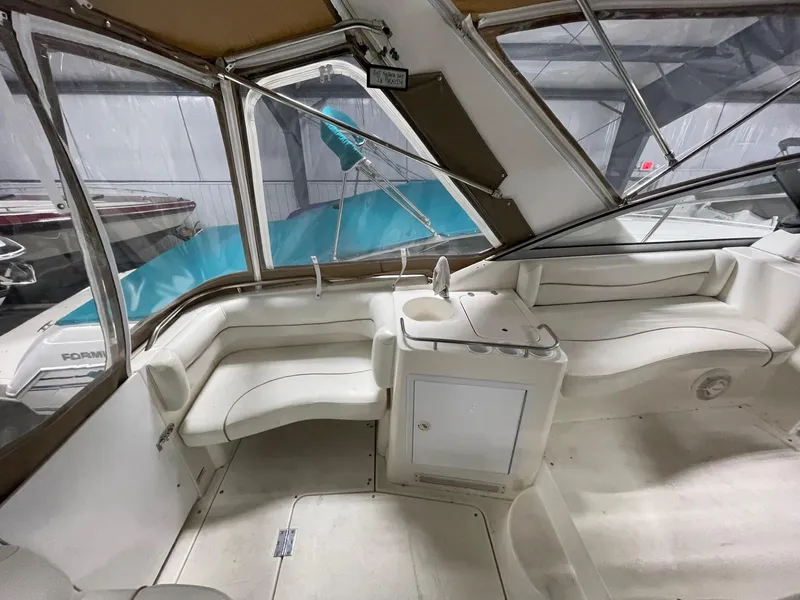 Slide: The Image of 1999 Larson 330 CABRIO boat interior with white seating and storage cabinet. - 6