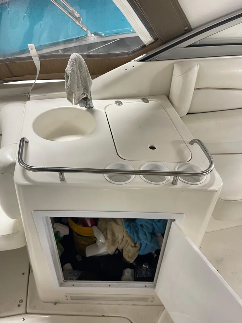 Slide: The Image of 1999 Larson 330 Cabrio boat interior with sink and storage area. - 7