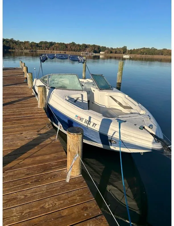 Slide: The Image of 2006 Rinker 296 Captiva Bowrider docked on a serene lake. - 4