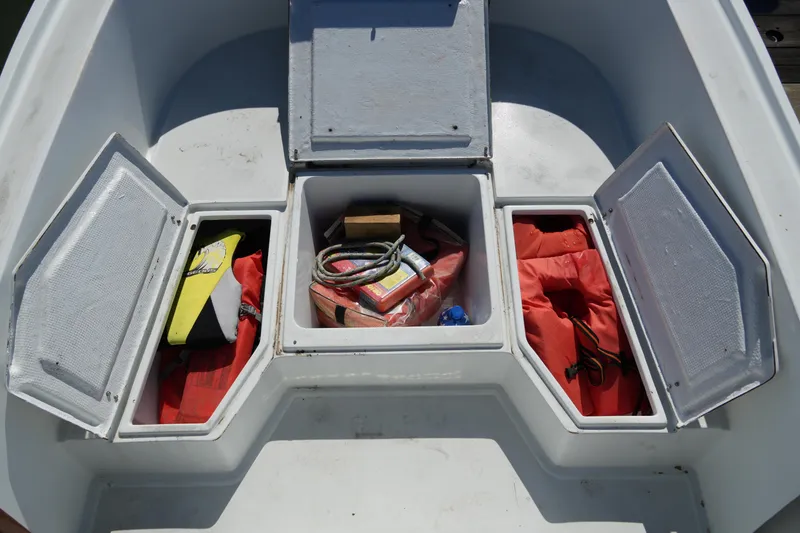 Slide: The Image of 1980 Mako 23 inboard boat storage compartments with safety gear and equipment. - 10