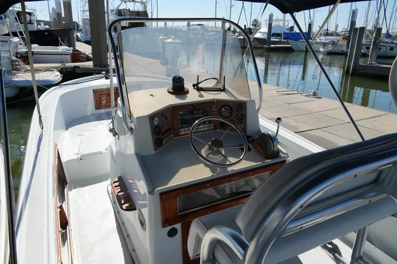 Slide: The Image of 1980 Mako 23 inboard boat with classic helm, docked at marina. - 11