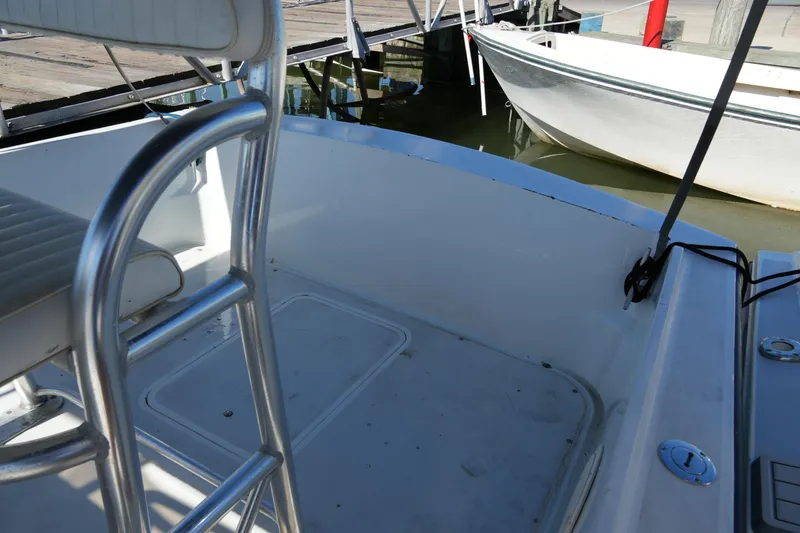 Slide: The Image of 1980 Mako 23 inboard boat interior with seating and dock view. - 12