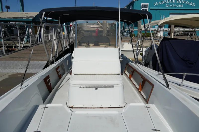 Slide: The Image of 1980 Mako 23 inboard boat at Seabrook Shipyard, featuring a spacious deck and canopy. - 5