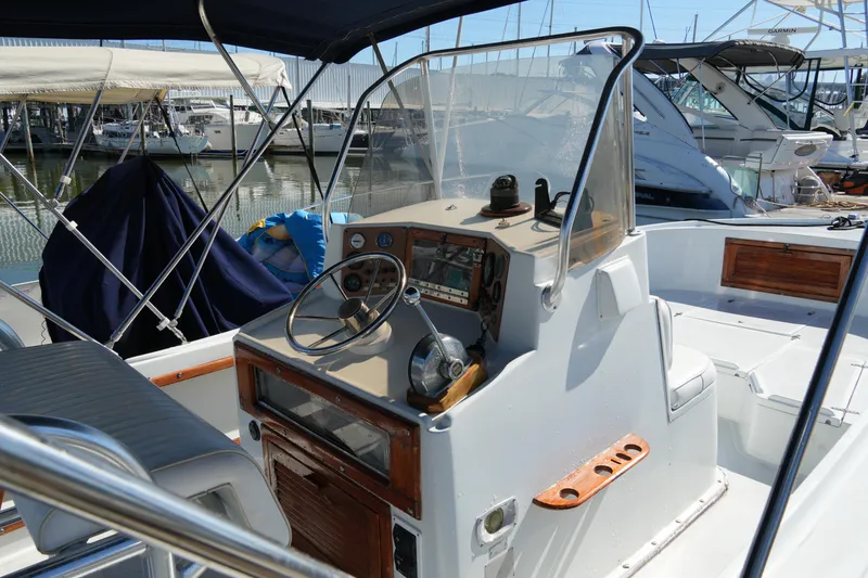 Slide: The Image of 1980 Mako 23 inboard boat with steering console, docked at marina. - 6