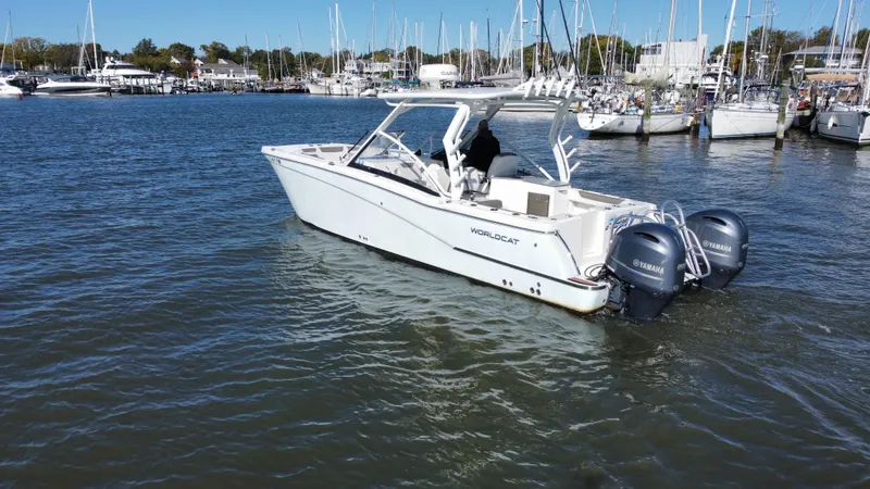 Slide: The Image of 2020 World Cat 280 DC x boat with twin Yamaha engines in a marina. - 2