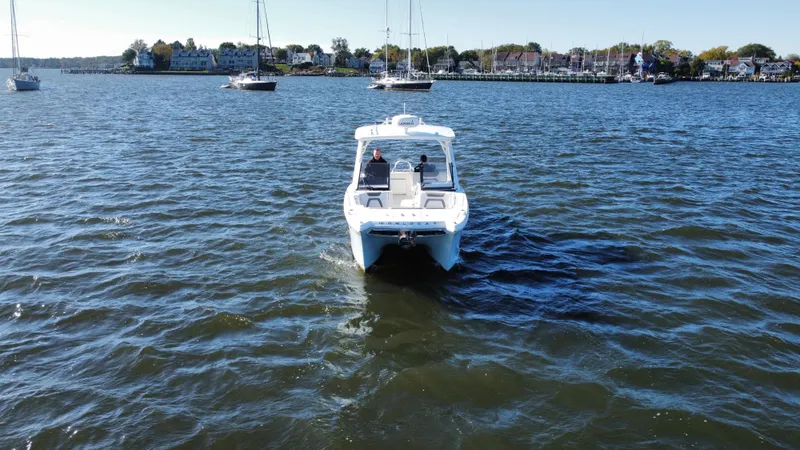 Slide: The Image of 2020 World Cat 280 DC x boat on calm water with sailboats in the background. - 30