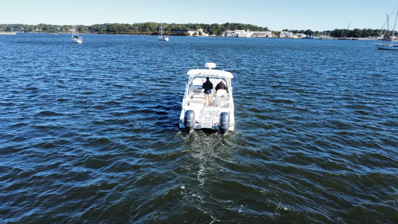 Slide: The Image of 2020 World Cat 280 DC x cruising on a serene lake with distant shoreline. - 31