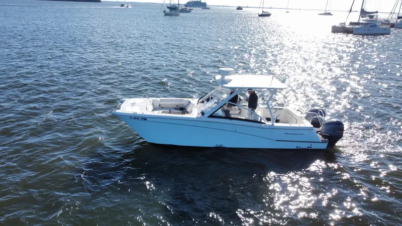 Slide: The Image of 2020 World Cat 280 DC x boat on sunny waters with other boats in the background. - 35