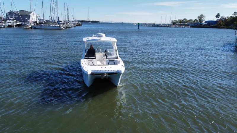 Slide: The Image of 2020 World Cat 280 DC x boat cruising in a marina with sailboats. - 4