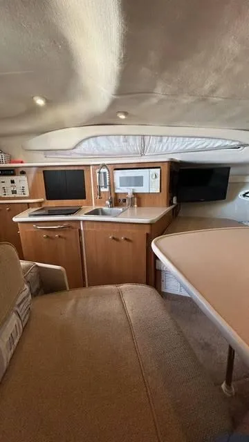 Slide: The Image of Interior of 2002 Bayliner 2655 Ciera boat with kitchenette and seating area. - 18
