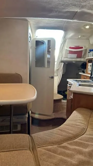 Slide: The Image of Interior of 2002 Bayliner 2655 Ciera boat, featuring cozy seating and kitchenette. - 19