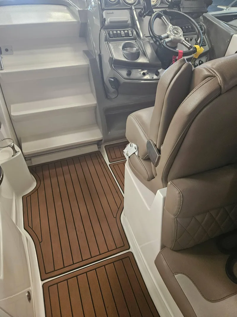Slide: The Image of Interior of a 2009 Monterey 260SCR boat with brown seating and wood-patterned flooring. - 13