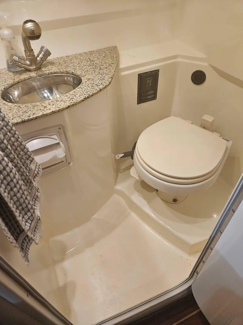 Slide: The Image of 2009 Monterey 260SCR boat bathroom with sink, toilet, and granite countertop. - 22