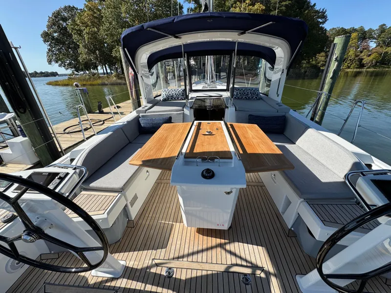 Slide: The Image of Beneteau Oceanis 46.1 yacht cockpit with dual steering wheels and wooden table, 2022 model. - 12