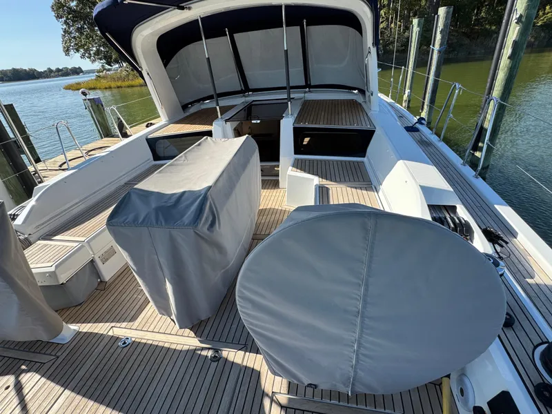 Slide: The Image of Beneteau Oceanis 46.1 yacht deck, 2022 model, featuring covered seating and helm, docked by water. - 18