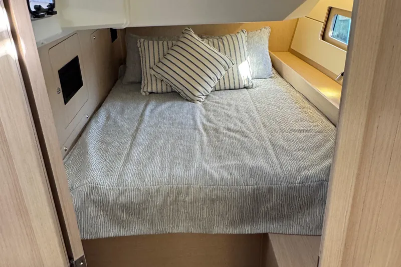Slide: The Image of Cozy cabin interior of 2022 Beneteau Oceanis 46.1 with striped bedding and pillows. - 24