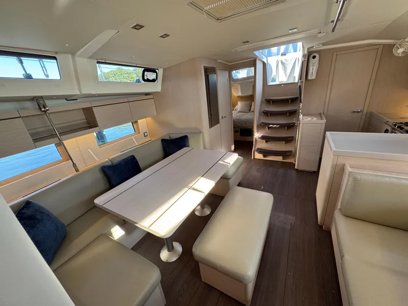 Slide: The Image of Interior of 2022 Beneteau Oceanis 46.1 yacht, featuring modern dining area and cozy seating. - 25