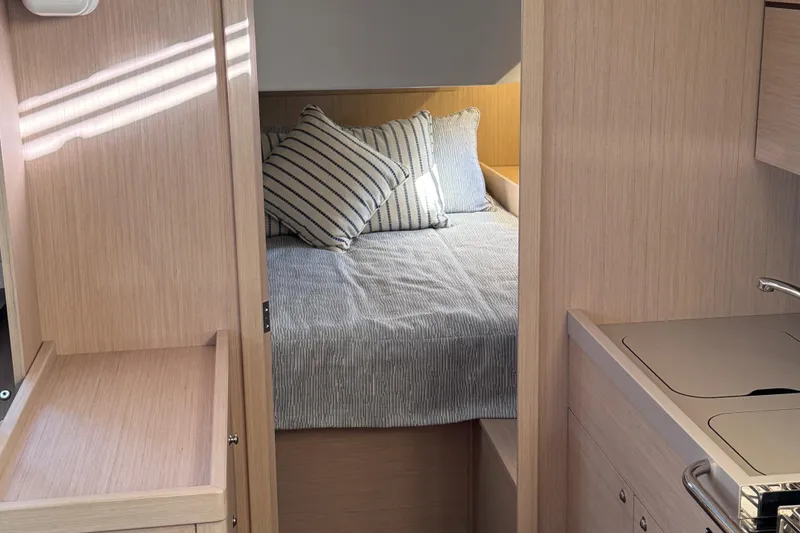 Slide: The Image of Interior cabin of 2022 Beneteau Oceanis 46.1 yacht with cozy bed and striped pillows. - 35