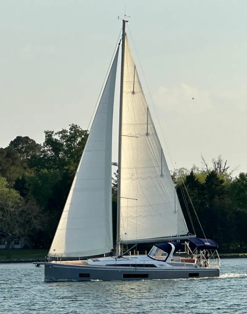 Slide: The Image of 2022 Beneteau Oceanis 46.1 sailing on a calm lake with lush greenery. - 37
