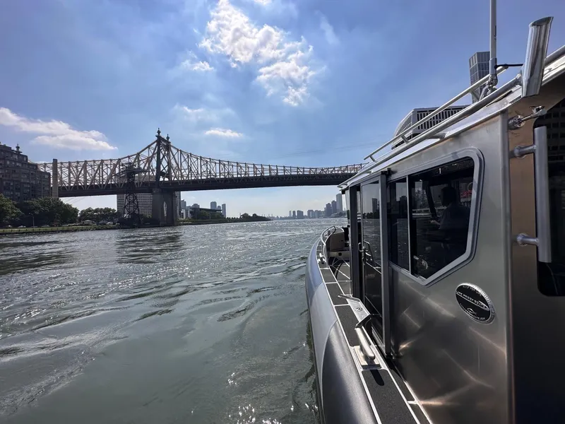 Slide: The Image of 2023 Life Proof 31 Walk Around Cabin boat on river near bridge under blue sky. - 4