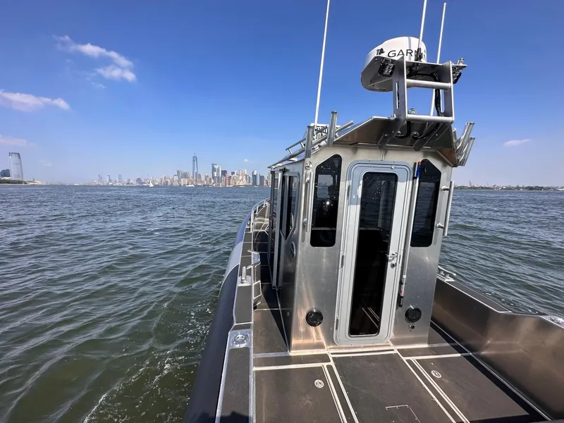 Slide: The Image of 2023 Life Proof 31 Walk Around Cabin boat on open water with city skyline. - 5