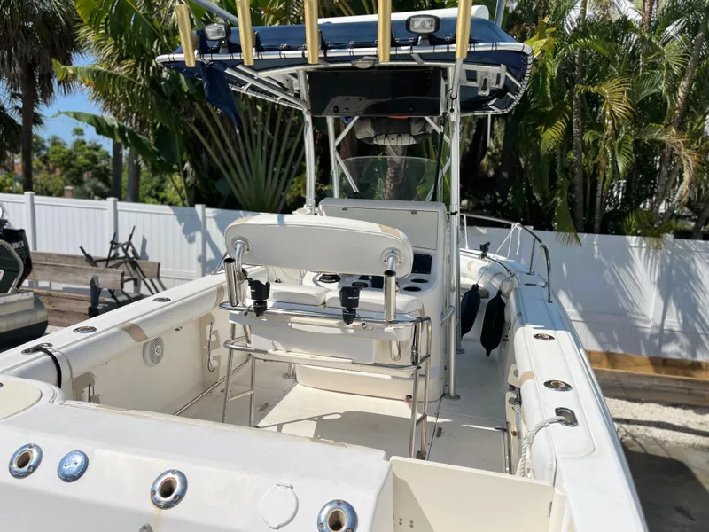 Slide: The Image of 2004 Boston Whaler 240 Outrage boat, white interior, outdoor setting with palm trees. - 12