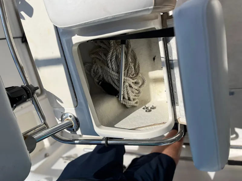 Slide: The Image of Open storage compartment on 2004 Boston Whaler 240 Outrage with coiled rope inside. - 19