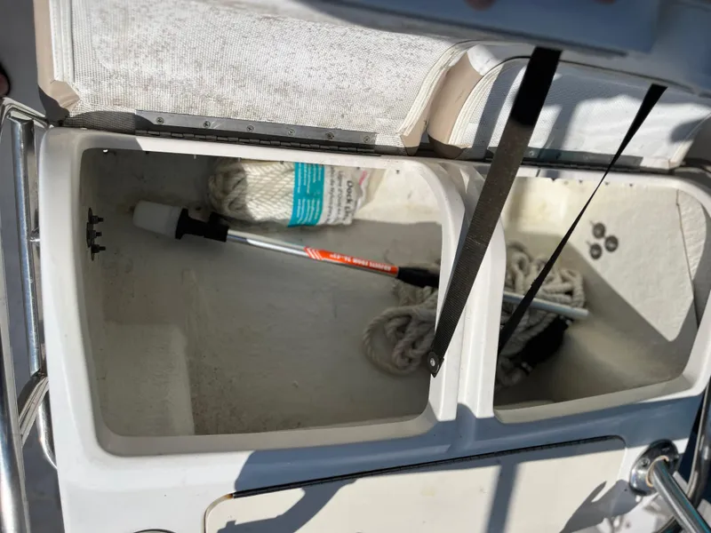 Slide: The Image of Open storage compartment on 2004 Boston Whaler 240 Outrage boat with ropes and equipment. - 20