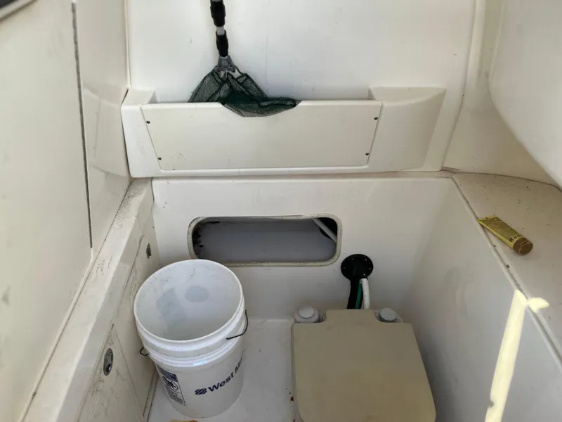 Slide: The Image of 2004 Boston Whaler 240 Outrage interior with bucket and storage compartment. - 27