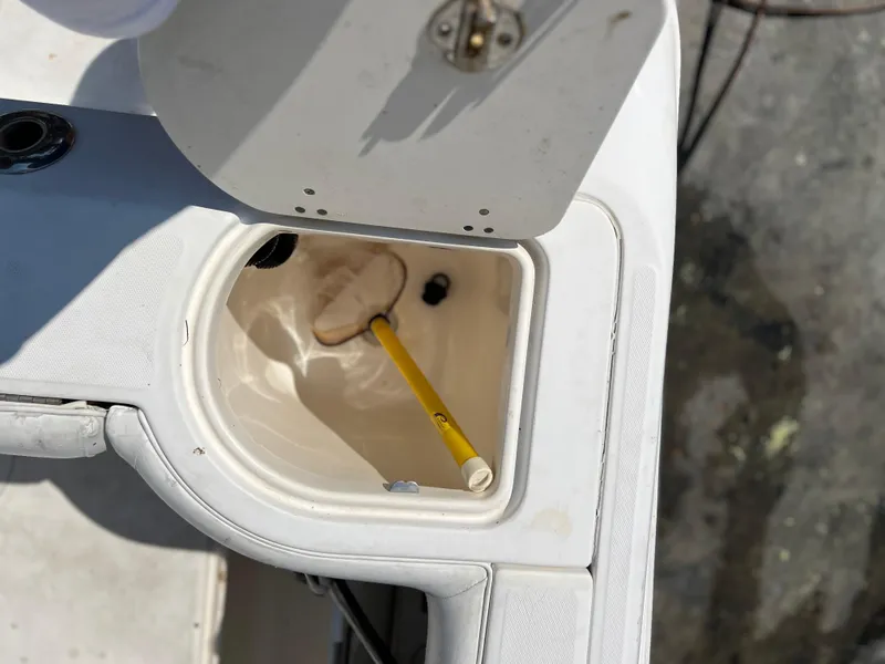 Slide: The Image of Open storage compartment on 2004 Boston Whaler 240 Outrage boat with yellow handle inside. - 28