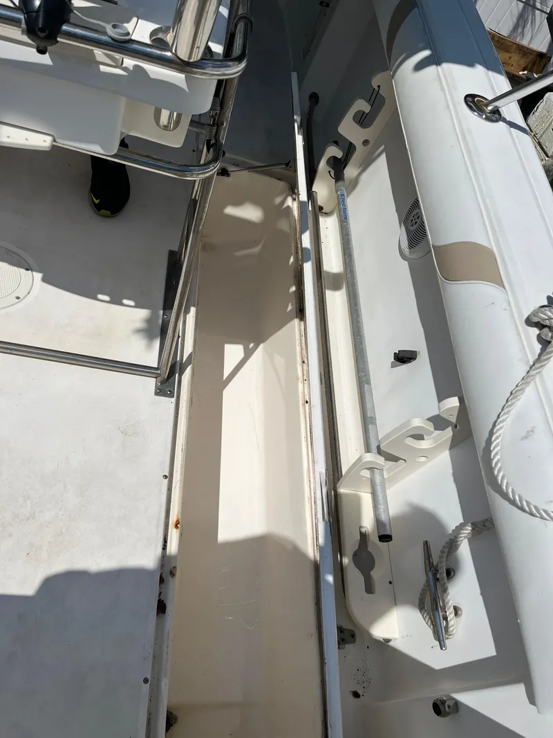 Slide: The Image of 2004 Boston Whaler 240 Outrage interior, showcasing storage compartment and seating area. - 38
