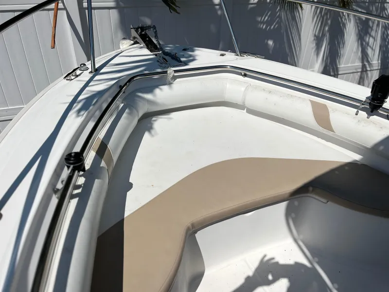 Slide: The Image of 2004 Boston Whaler 240 Outrage boat interior with cushioned seating and railings. - 4