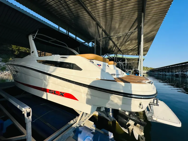 Slide: The Image of 2015 Sea Ray 250 SLX boat docked under a covered marina. - 10
