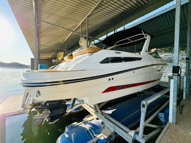 Slide: The Image of 2015 Sea Ray 250 SLX boat docked under a covered marina. - 11