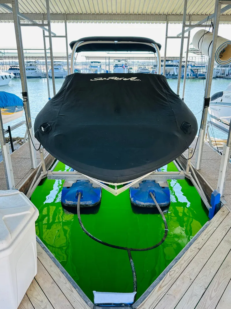 Slide: The Image of 2015 Sea Ray 250 SLX boat docked, covered, with vibrant green water below. - 14