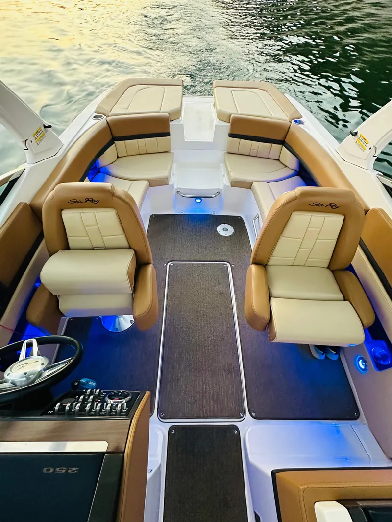 Slide: The Image of 2015 Sea Ray 250 SLX boat interior with tan leather seats and blue LED lighting. - 15