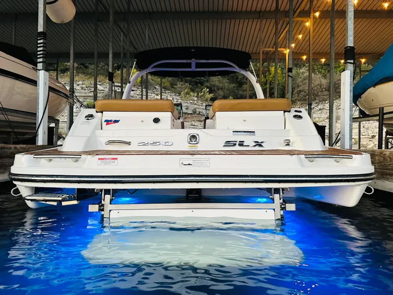 Slide: The Image of 2015 Sea Ray 250 SLX boat with illuminated blue underwater lights in a marina. - 16