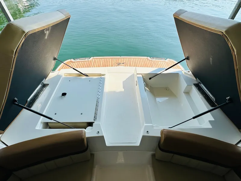 Slide: The Image of 2015 Sea Ray 250 SLX boat interior with open storage compartments, overlooking water. - 26