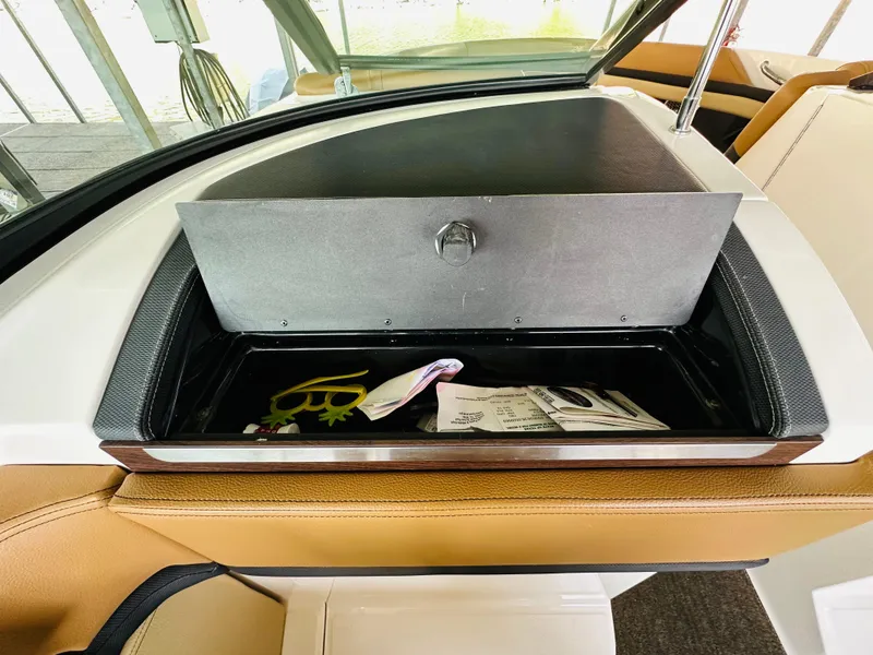 Slide: The Image of Open glove compartment in 2015 Sea Ray 250 SLX boat with documents and keys. - 32
