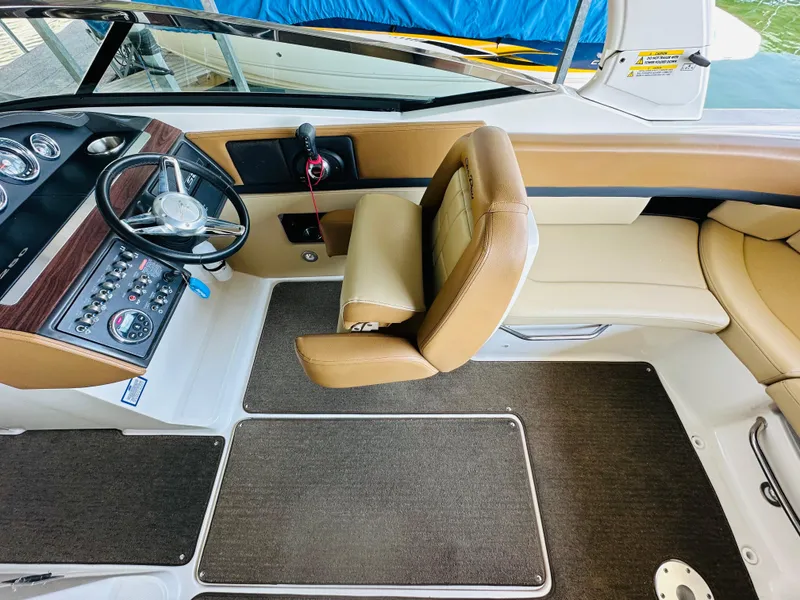 Slide: The Image of 2015 Sea Ray 250 SLX boat interior with tan seating and control panel. - 34