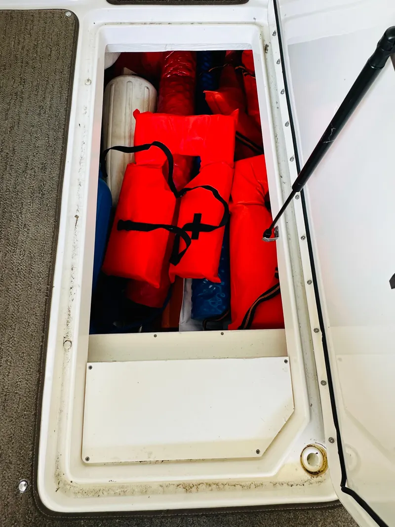 Slide: The Image of Storage compartment on 2015 Sea Ray 250 SLX with life jackets and fenders. - 35