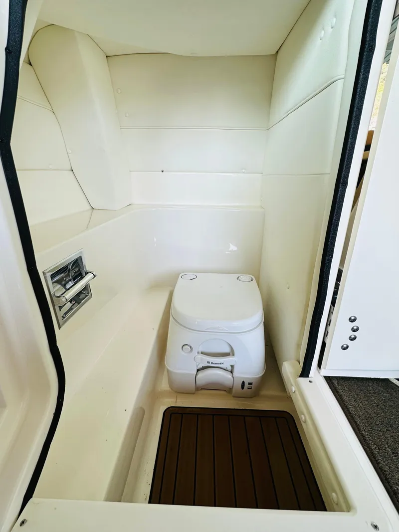 Slide: The Image of 2015 Sea Ray 250 SLX boat interior with compact marine toilet. - 48