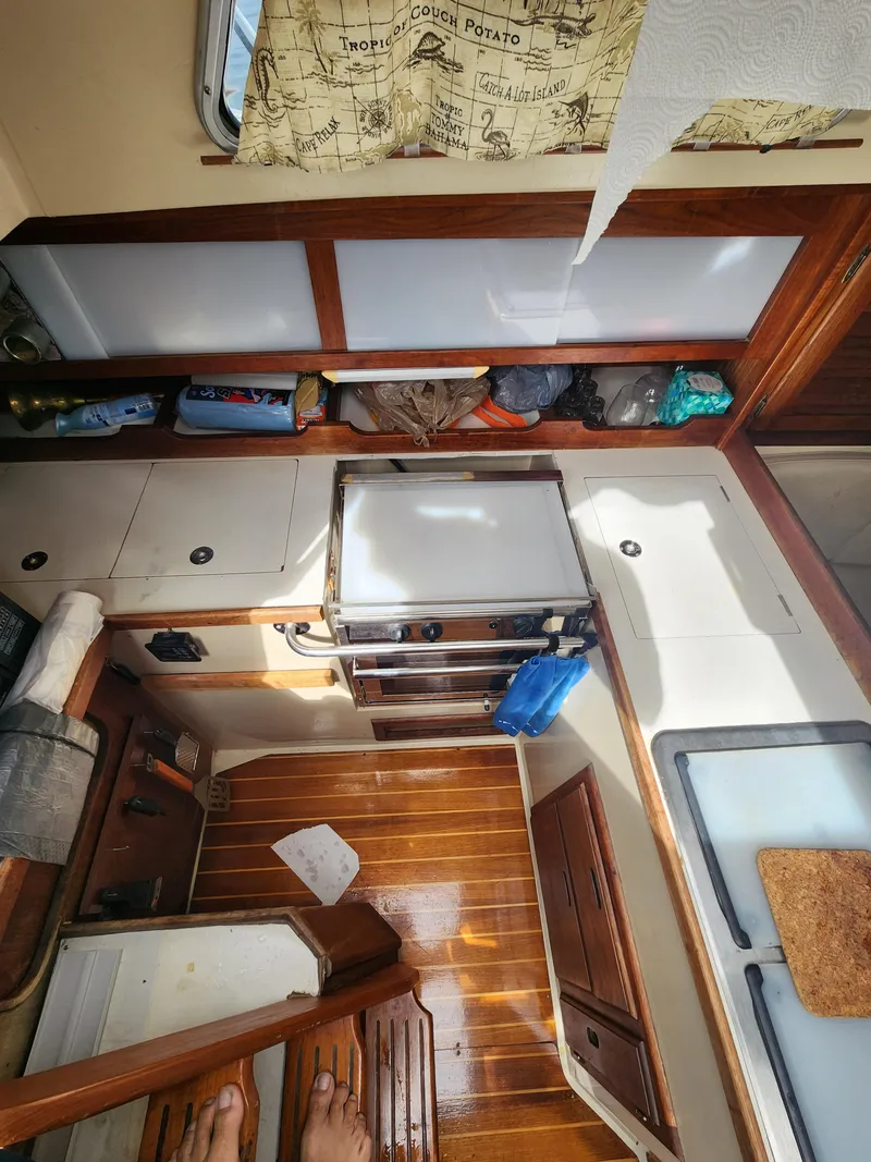 Slide: The Image of Interior of 1987 Catalina 36 sailboat galley with wooden flooring and storage cabinets. - 18