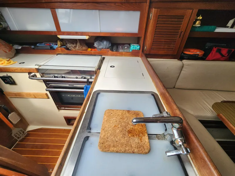 Slide: The Image of 1987 Catalina 36 yacht kitchen with stove, sink, and wooden cabinetry. - 24