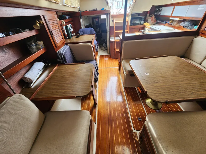 Slide: The Image of Interior of a 1987 Catalina 36 sailboat with wooden flooring and cozy seating. - 28