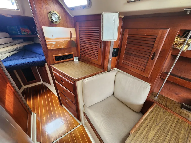 Slide: The Image of Interior of 1987 Catalina 36 sailboat with wooden cabinetry and cozy seating area. - 29